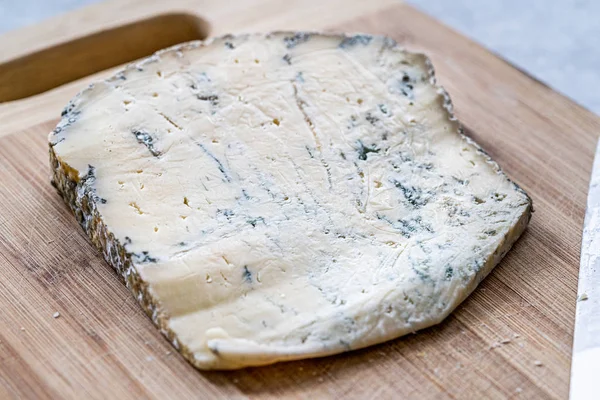 Queijo azul francês de Roquefort inteiro com faca na placa de madeira . — Fotografia de Stock