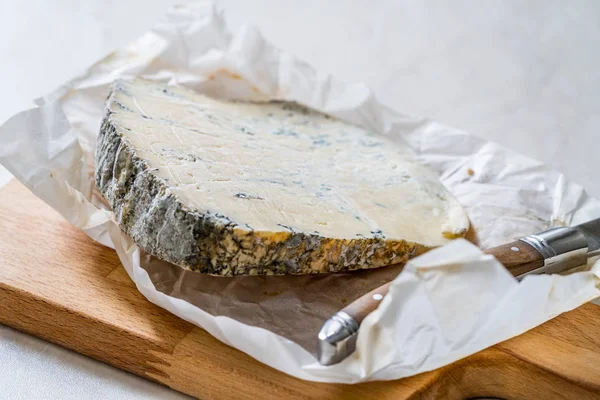 Целый Рокфор Французский голубой сыр с ножом на деревянной доске . — стоковое фото