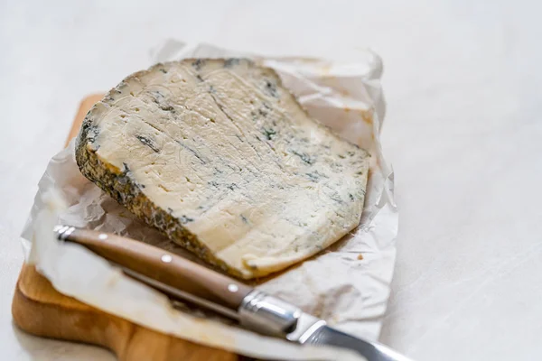 Queijo azul francês de Roquefort inteiro com faca na placa de madeira . — Fotografia de Stock