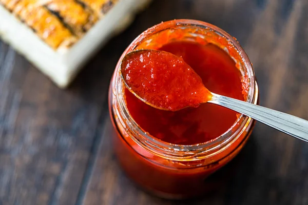 Red Hot Chili peper saus voor ambachtelijke kaas gemaakt met azijn en suiker in glazen schaal met lepel. — Stockfoto