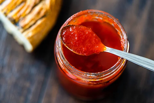 Red Hot Chili peper saus voor ambachtelijke kaas gemaakt met azijn en suiker in glazen schaal met lepel. — Stockfoto