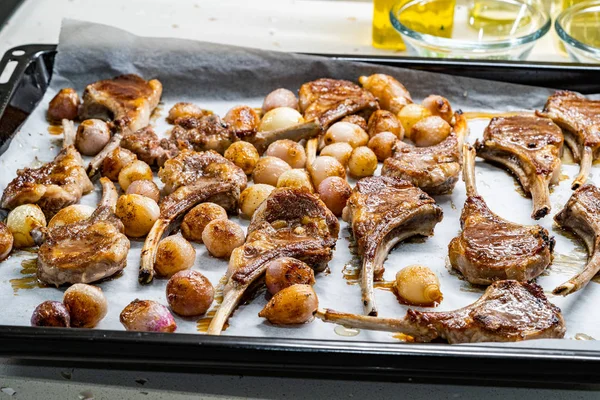 Baked Lamb Chops with Shallots on Baking Tray with Paper Sheet.