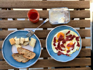 Sucuk Kızarmış Yumurta, Çeşitli Peynir, Bal ve Kırmızı Acı Biber Sosu ile Türk Kahvaltısı. Yemeye hazır..