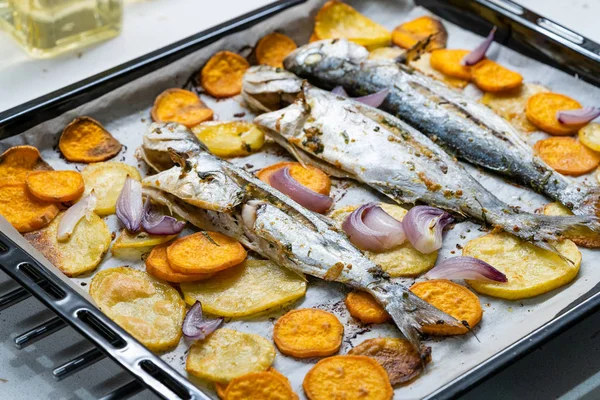 Pește copt albastru cu cartofi dulci pe tava de cuptor cu foaie de hârtie de copt / Lufer. Fructe de mare . — Fotografie, imagine de stoc