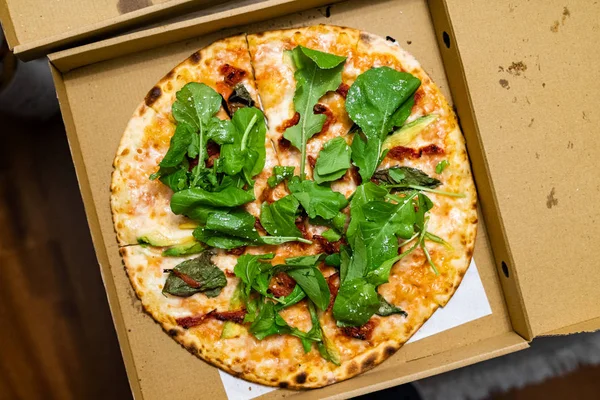 Take Away Pizza Box with Arugula, Rocket or Rucola Leaves and Avocado. Ready to Eat.