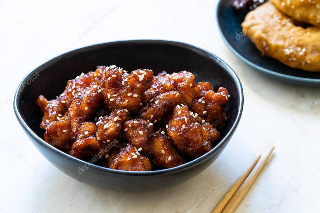 Asian Food Homemade Chinese General Tsos Chicken with Sesame Seeds served with Chopsticks. Traditional Food.