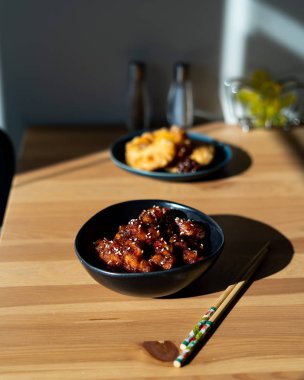 Yemek çubuklarıyla servis edilen susamlı Çin yemeği General Tsos tavuğu. Geleneksel Yemek.