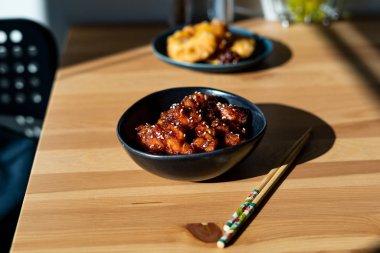 Yemek çubuklarıyla servis edilen susamlı Çin yemeği General Tsos tavuğu. Geleneksel Yemek.