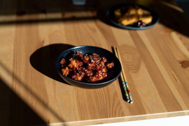 Yemek çubuklarıyla servis edilen susamlı Çin yemeği General Tsos tavuğu. Geleneksel Yemek.