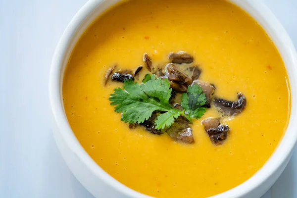 Homemade Thai Sweet Potato Soup with Cilantro, Coconut Milk Cream, Lime and Mushrooms. Traditional Beverage Concept.