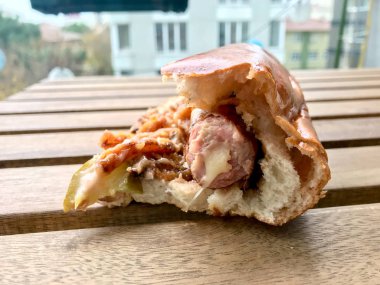 Tahta Masada Peynirle Dolu Isırılmış Sosisli Sandviç.