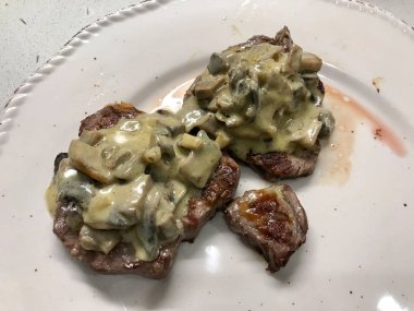 Mantar krem soslu et bifteği tabakla servis edilir. Proteinli organik gıda.
