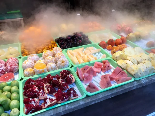Street Fruits ze Steam na sprzedaż. Granat, arbuz, kiwi, mandarynka, ananas i parzona pomarańcza we mgle oparów. Żywność ekologiczna. — Zdjęcie stockowe