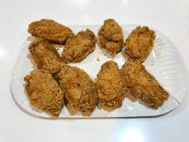 Bisküvi Ekmekli Kentucky usulü Tavuk Kanatları 'nı Plastik Tepside Fırçalayın. Fast Food.