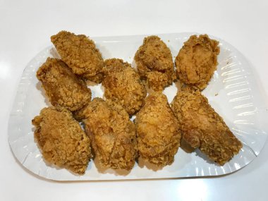 Bisküvi Ekmekli Kentucky usulü Tavuk Kanatları 'nı Plastik Tepside Fırçalayın. Fast Food.