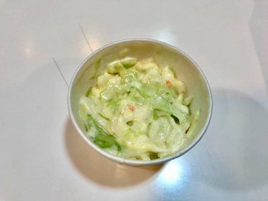 Lahana salatasını plastik kutuya koyup mermer yüzeyde fast food salatası yemeye hazır hale getirin..