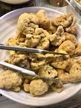 Çökmüş ve Kızarmış Karnabahar. Kızarmış sebzeler Metal Çelik Mutfak Tong Organik Gıda ile servis etmeye hazır..