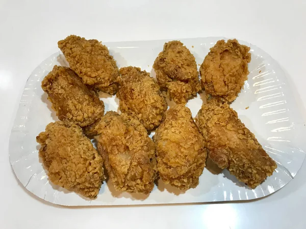 Πάρτε μακριά πικάντικα βαθιά τηγανητά αγκαθωτά φτερά κοτόπουλου στυλ Κεντάκι με ψωμί μπισκότο σε πλαστικό δίσκο. Γρήγορο φαγητό. — Φωτογραφία Αρχείου