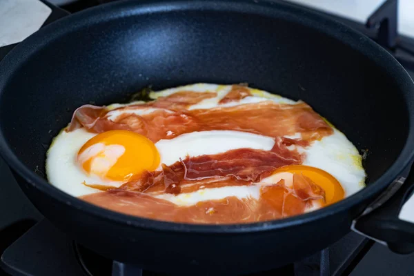 Uova fritte con prosciutto in padella per colazione. Pronto da mangiare . — Foto Stock