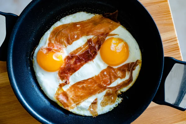 Sült tojás Prosciutto-val Pan-ban reggelire. Kész az evésre. Bioélelmiszerek. — Stock Fotó