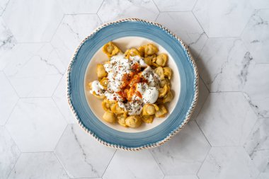 Et, yoğurt, domates sosu ve baharatlı ev yapımı Rus Pelmeni kızartması. Geleneksel Sağlıklı Yemek.