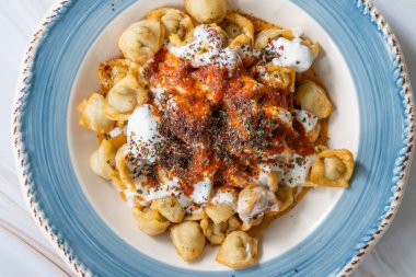 Et, yoğurt, domates sosu ve baharatlı ev yapımı Rus Pelmeni kızartması. Geleneksel Sağlıklı Yemek.
