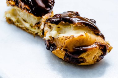 Half Cut Cream Filled French Dessert Chocolate Eclair. Close Up Macro View. Traditional Dessert.