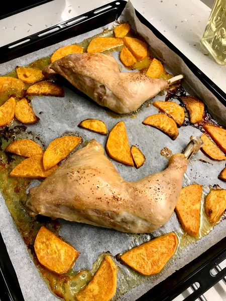 Pernas de frango assadas orgânicas saudáveis com batatas doces na bandeja de cozimento com papel de folha. Pronto para comer . — Fotografia de Stock