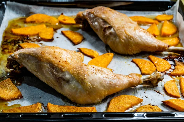 Gesunde Bio-gebackene Hühnerkeulen mit Süßkartoffeln auf Backblech mit Blech. Fertig zum Essen. — Stockfoto