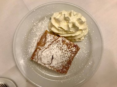 Orijinal Geleneksel Apple Strudel, Viyana, Avusturya 'da Apfelstrudel. Restoran ortamında beyaz bir tabakta servis edilmiş. Vanilyalı dondurma, pudra şekeri ve nane yaprağı. Yemeye hazır..