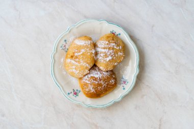 Mandazi is a slightly sweet East African Street Food; spicy, airy yeast doughnut dough made with coconut milk, flavored with cardamom and grated fresh coconut. Traditional Dish.