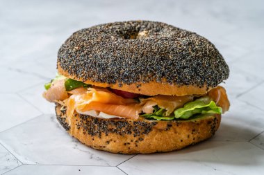 Somonlu bagel sandviçi, krem peynirli ve haşhaş tohumlu. Organik Sağlıklı Fast Food.