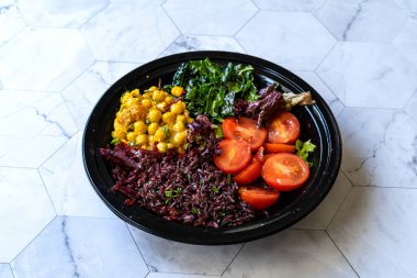 Turmerik Nohut, Kale, Kiraz Domatesli, Yasak Pirinç veya Oryza Sativa ile sağlıklı Siyah Pirinç Salatası. Ev yapımı organik gıdalar..