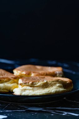 Ev yapımı yumuşak sufle krepi siyah tabakta kahvaltıda yemeye hazır..