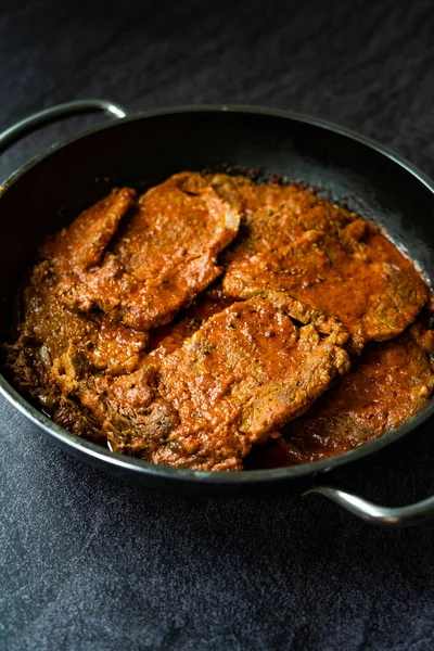 Homemade Slow Cooked Mexican Style Beef Meat with Tomato Paste Sauce in Pan. Cooked