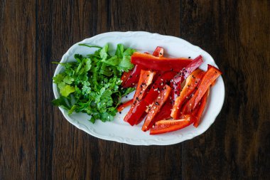 Antioksidanlı salata Julienne dilimlenmiş kırmızı çan biber dilimleri ve susam tohumlu maydanoz ve zeytinyağı. Sağlıklı Organik Gıda.