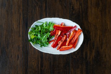 Antioksidanlı salata Julienne dilimlenmiş kırmızı çan biber dilimleri ve susam tohumlu maydanoz ve zeytinyağı. Sağlıklı Organik Gıda.