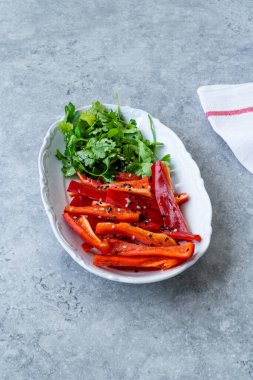 Antioksidanlı salata Julienne dilimlenmiş kırmızı çan biber dilimleri ve susam tohumlu maydanoz ve zeytinyağı. Sağlıklı Organik Gıda.