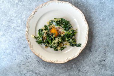 Tabakta kızarmış yumurtalı ev yapımı ıspanak. Sağlıklı Organik Sıcak Yemek.