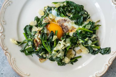 Tabakta kızarmış yumurtalı ev yapımı ıspanak. Sağlıklı Organik Sıcak Yemek.