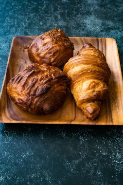 Muhtelif Kruvasan çeşitleri ahşap tabak çeşitleri ve fırın hamur işleri çeşitleri. Yemeye hazır..