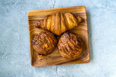 Muhtelif Kruvasan çeşitleri ahşap tabak çeşitleri ve fırın hamur işleri çeşitleri. Yemeye hazır..