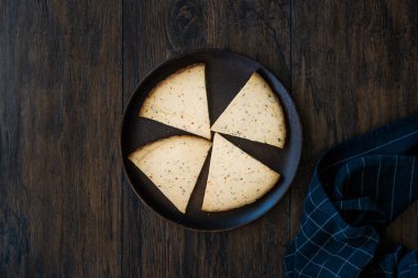 Baharatlı Çerkez Üçgeni Koyu Ahşap Tabakta Füme Peynir Dilimleri ve Baharatlar. Yemeye hazır..