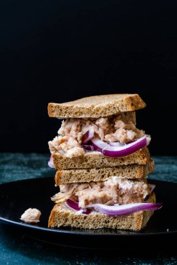 Kırmızı soğanlı ton balıklı sandviç, mayonez ve çok tahıllı kızarmış ekmek. Sağlıklı Organik Fast Food.
