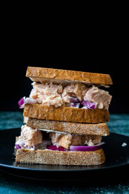 Kırmızı soğanlı ton balıklı sandviç, mayonez ve çok tahıllı kızarmış ekmek. Sağlıklı Organik Fast Food.