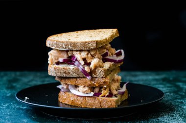 Kırmızı soğanlı ton balıklı sandviç, mayonez ve çok tahıllı kızarmış ekmek. Sağlıklı Organik Fast Food.