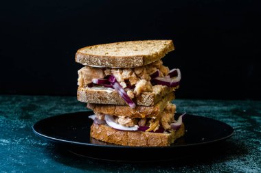 Kırmızı soğanlı ton balıklı sandviç, mayonez ve çok tahıllı kızarmış ekmek. Sağlıklı Organik Fast Food.