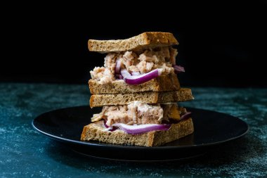 Kırmızı soğanlı ton balıklı sandviç, mayonez ve çok tahıllı kızarmış ekmek. Sağlıklı Organik Fast Food.