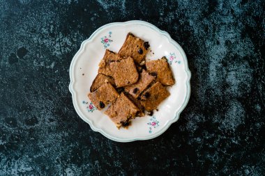 Muz ve çikolata parçacıkları ile şekillendirilmiş organik çiğ çiğ yulaf keki. Organik Tatlı.