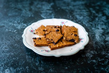 Muz ve çikolata parçacıkları ile şekillendirilmiş organik çiğ çiğ yulaf keki. Organik Tatlı.